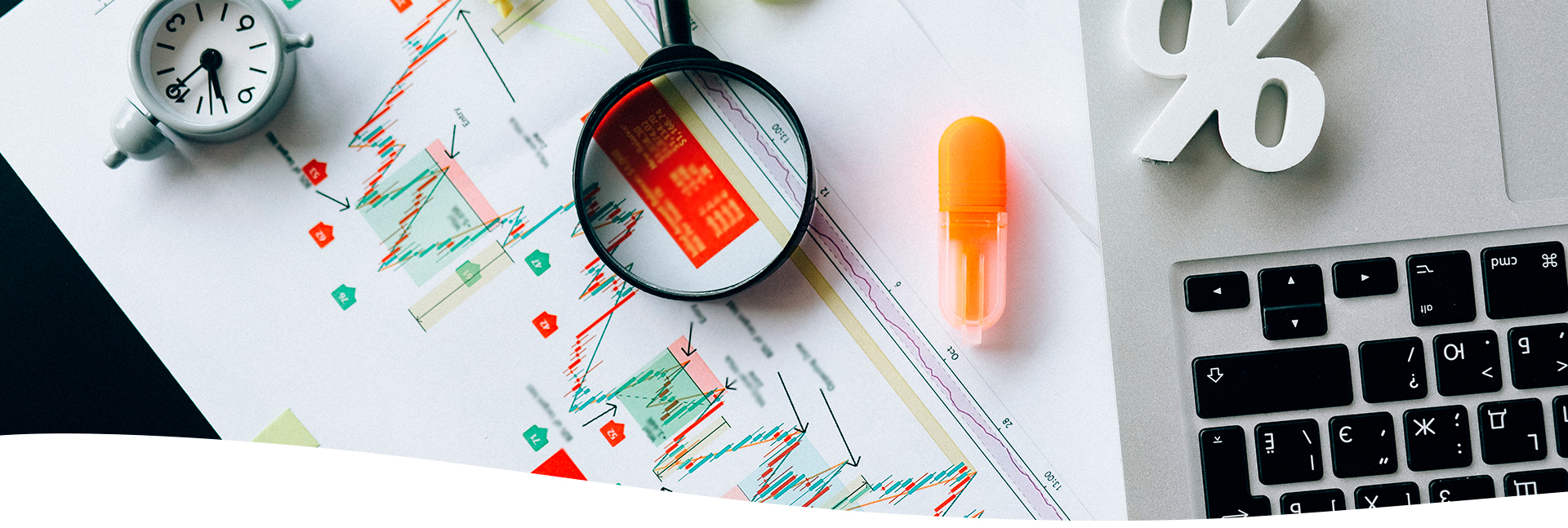 Lupa, reloj y laptop.