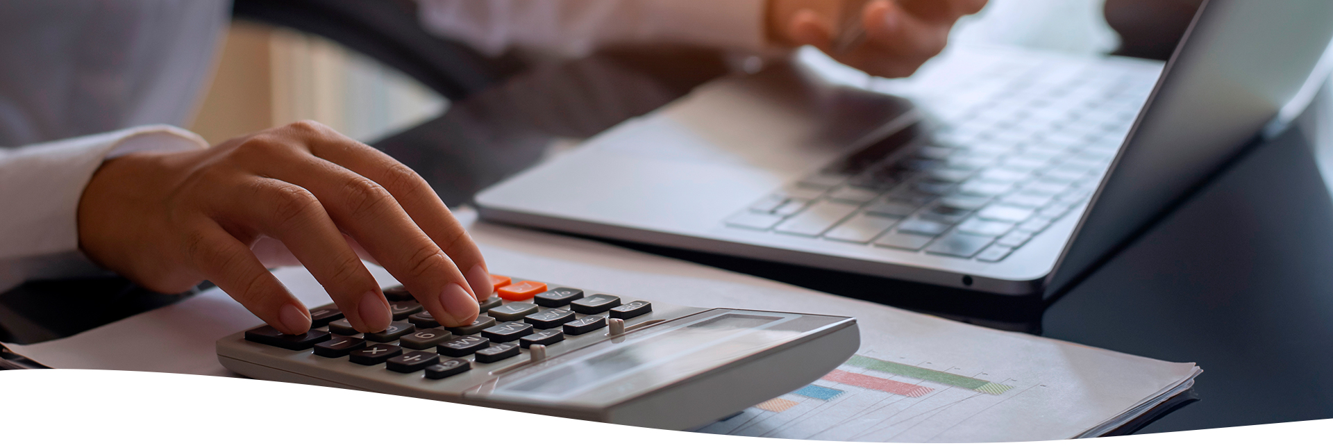 Mujer empresarial utilizando su celular y la calculadora en la oficina