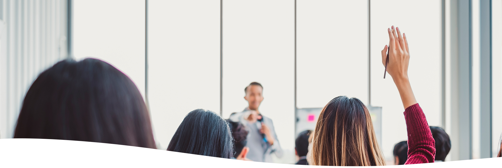 Mujer levantando la mano para solicitar su participación en una conferencia o seminario